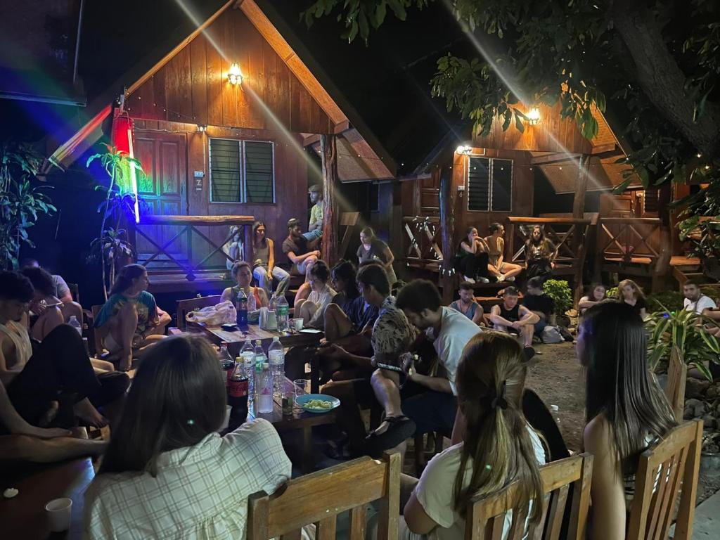 a group of people sitting at a table at night at Benny's House in Pai