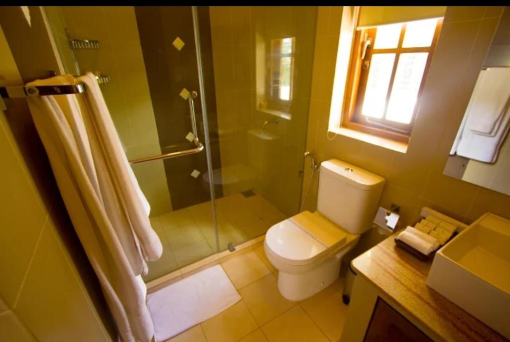 a bathroom with a toilet and a glass shower at Ellen’s Place in Colombo