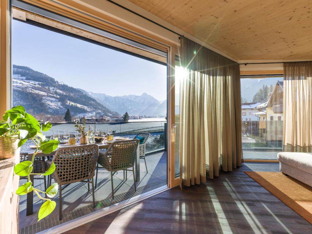 a balcony with a table and chairs and a large window at Villa Himmlgassl Private Spa in Zellbergeben