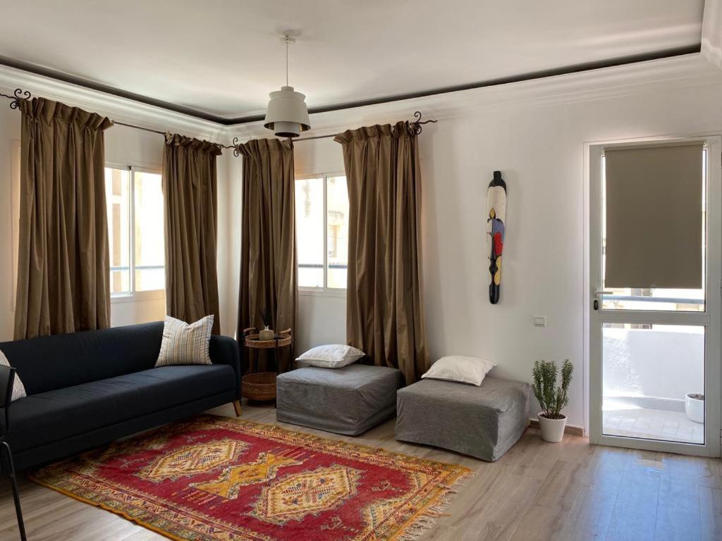 sala de estar con sofá y 2 reposapiés en Appartement 2 chambres salon en Casablanca