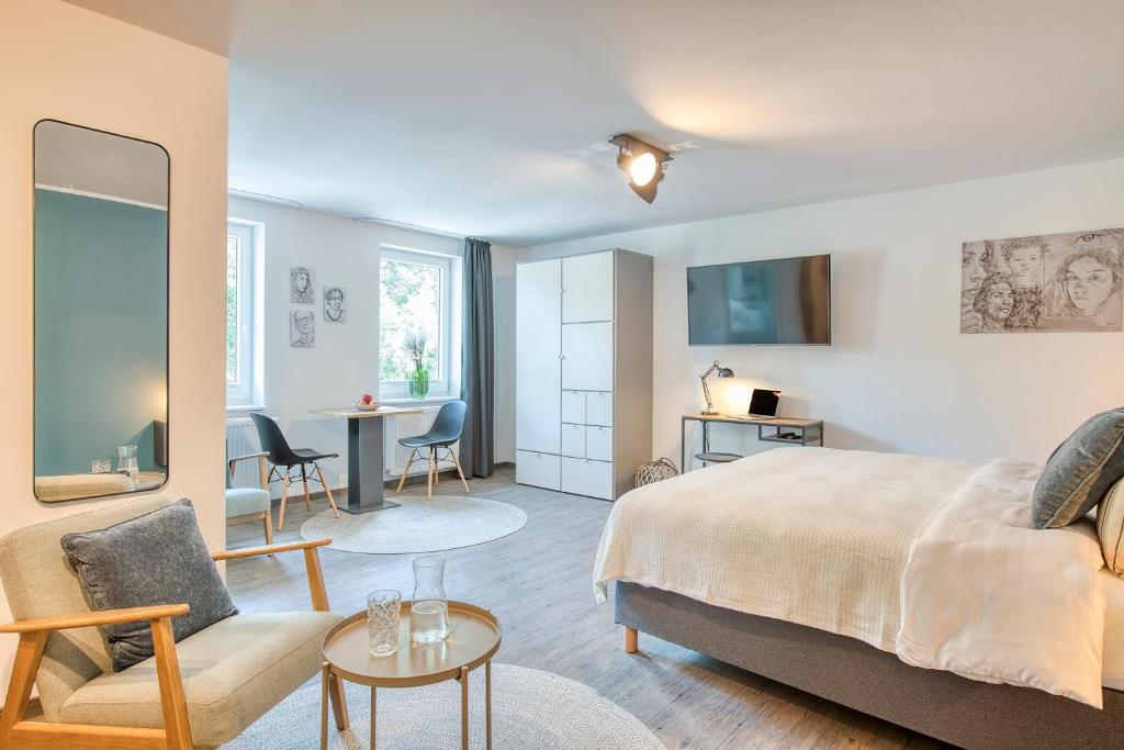a bedroom with a bed and a living room at BLEIBEREI Apartments in Göttingen