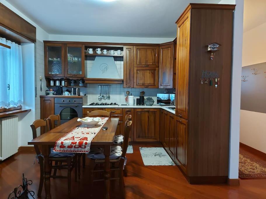 a kitchen with a wooden table and a table and chairs at Rendena Dolomiti House CIPAT 022244-AT-012660 in Porte di Rendena