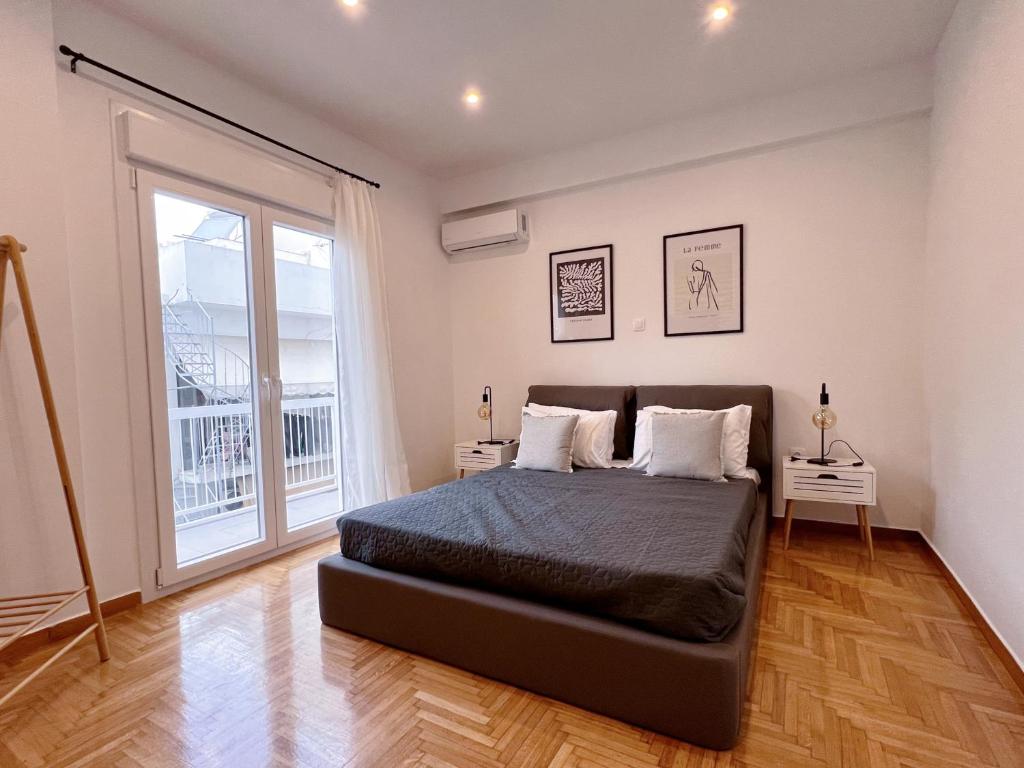 - une chambre avec un lit et une grande fenêtre dans l'établissement WSD Piraeus Amazing Luxury Boutique 2BD Apartment with balcony, au Pirée