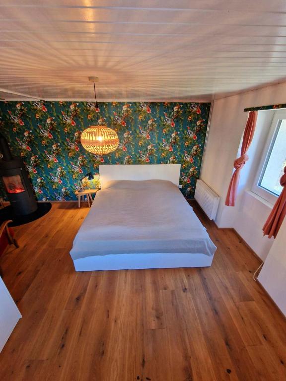 a bedroom with a bed and a chandelier at Kunstplanet im Herzen der Alpen am Planetenweg in Visp