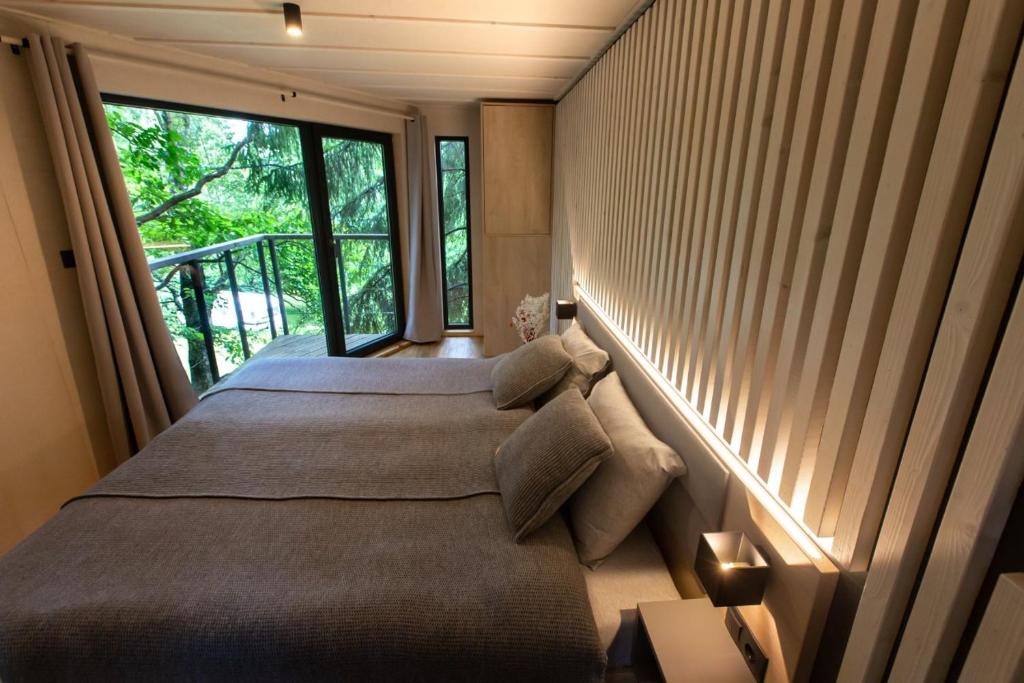 a bedroom with a large bed with a large window at Treehouse Karpacz in Karpacz