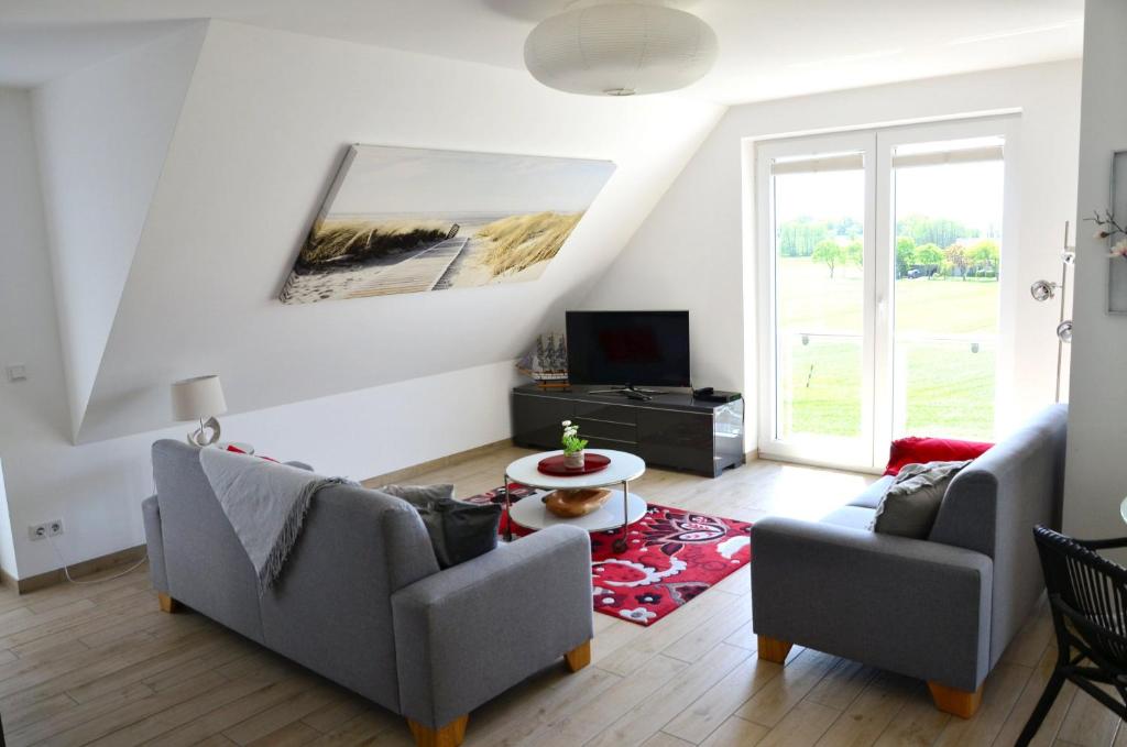 a living room with two couches and a tv at Ferienwohnung Auszeit in Ueckeritz