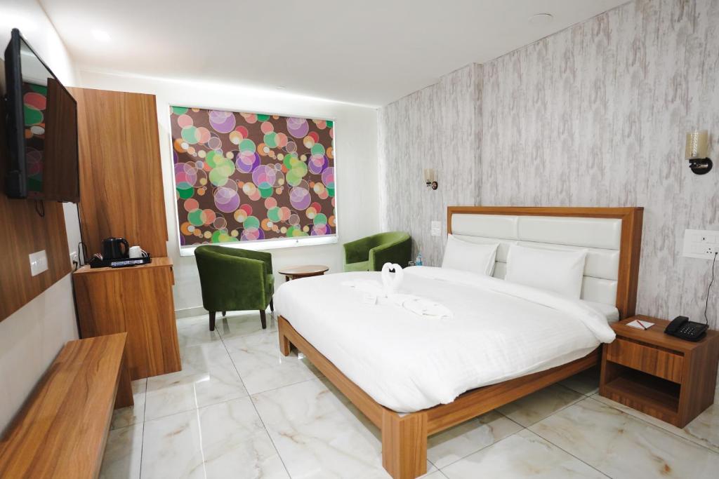 a bedroom with a large bed and a desk and chair at Hotel Northwind Mohali in Mohali
