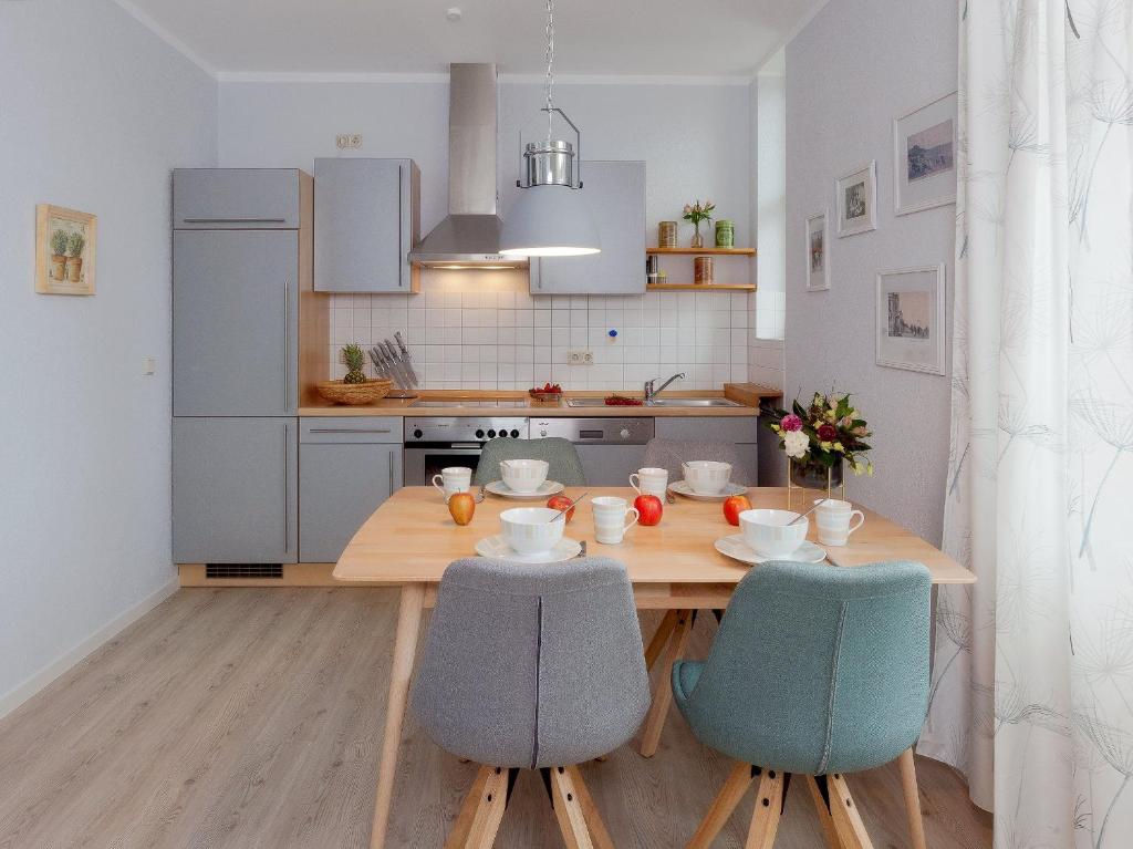 eine Küche mit einem Holztisch und zwei Stühlen in der Unterkunft Villa Frisia Nr 29 in Bansin