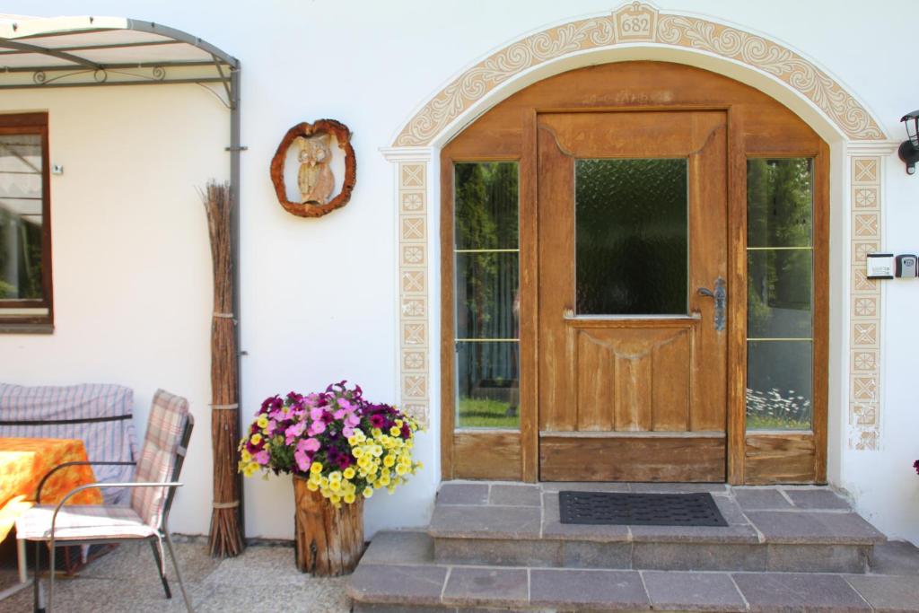 drewniane drzwi na domu z wazonem kwiatów w obiekcie Haus Alice w mieście Seefeld in Tirol