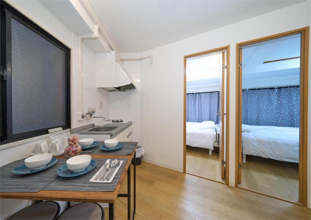 una pequeña cocina con mesa y un dormitorio en Aurora 3, en Tokio