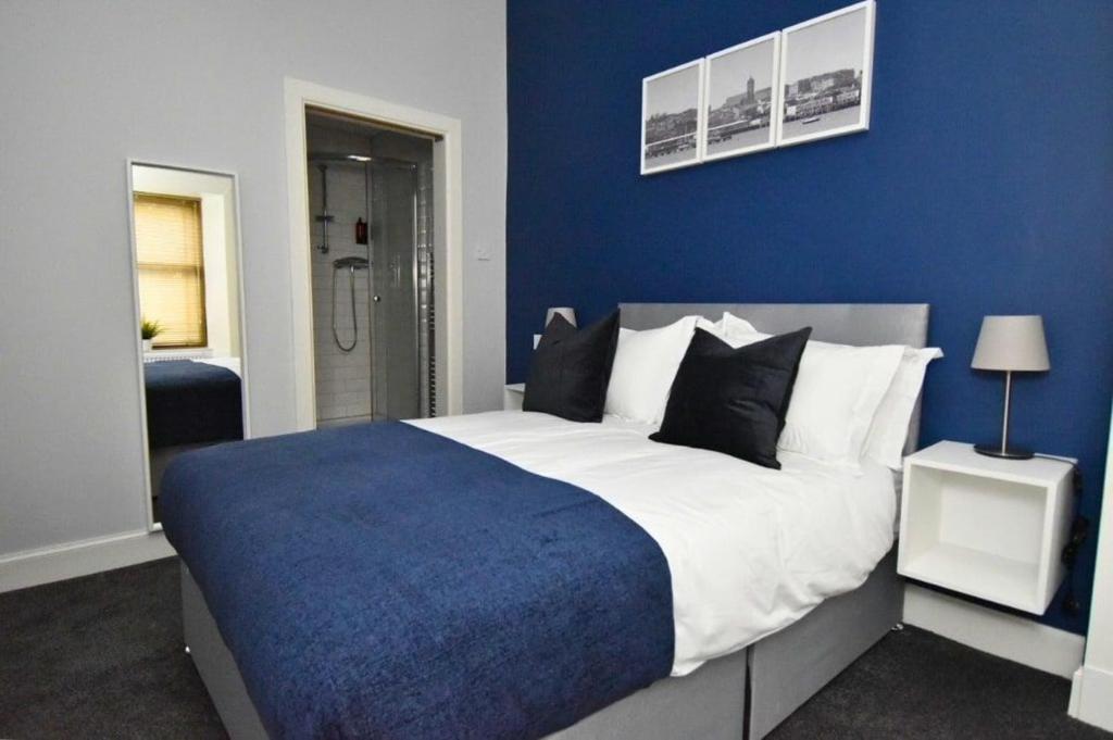 een slaapkamer met een groot bed met blauwe muren bij The Kempock in Gourock