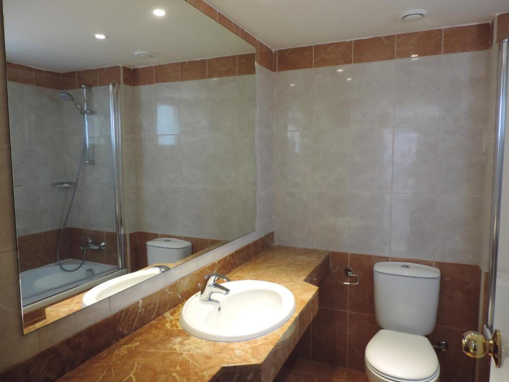 a bathroom with a sink and a toilet and a shower at Corfu Hotel in Ayia Napa