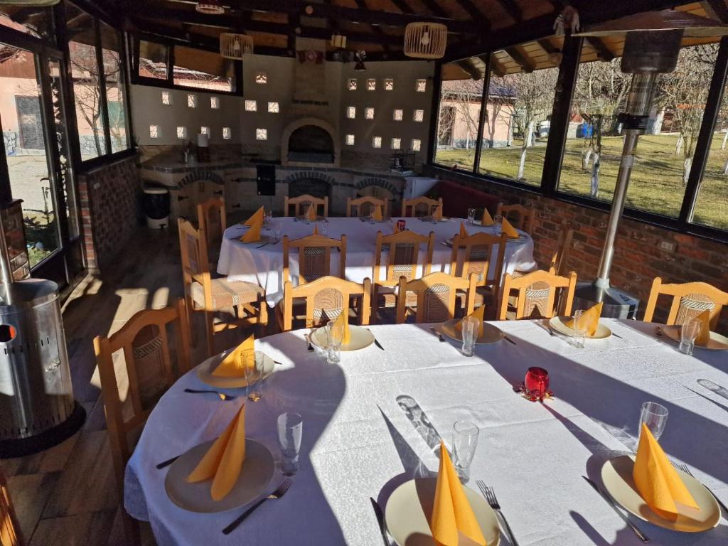 a dining room with white tables and chairs at Vila Drumetului in Comarnic