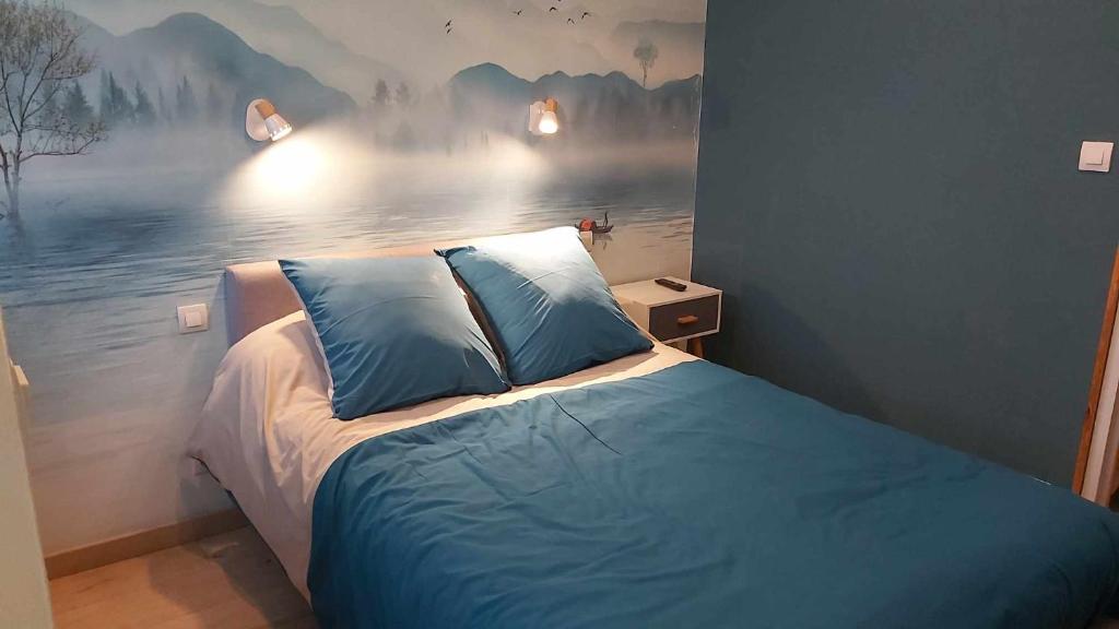 een slaapkamer met een bed met een schilderij aan de muur bij La Renaissance in Condé-sur-Noireau
