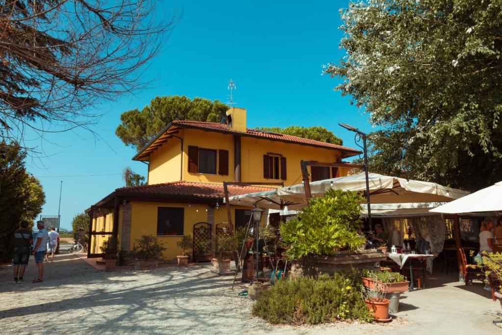 een geel huis waar mensen voor staan bij Agriturismo da Pudech in Ravenna