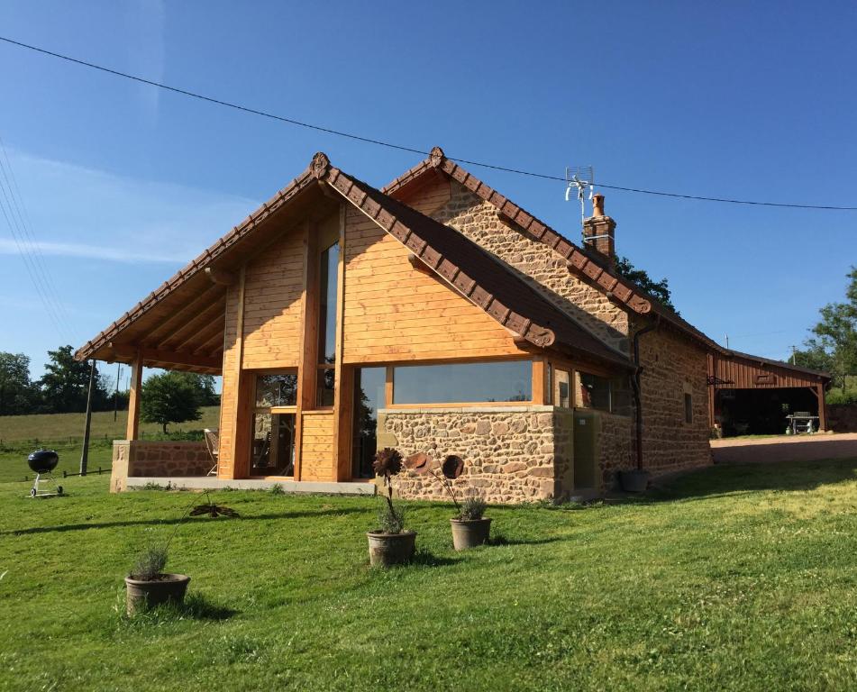 une maison dans un champ avec une pelouse dans l'établissement Les Perruchons ancienne grange rénovée avec soin, à Ozolles