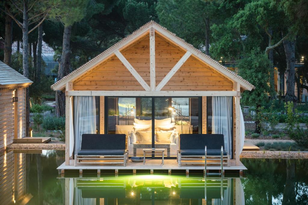 um gazebo com duas cadeiras sobre a água em Sublime Comporta Country Retreat & SPA na Comporta