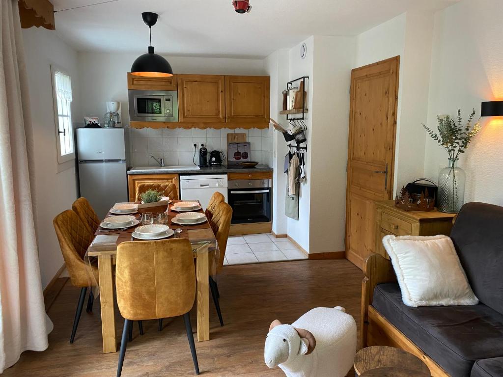 een keuken en een woonkamer met een tafel en een bank bij Côté DÔMES in Saint-Gervais-les-Bains