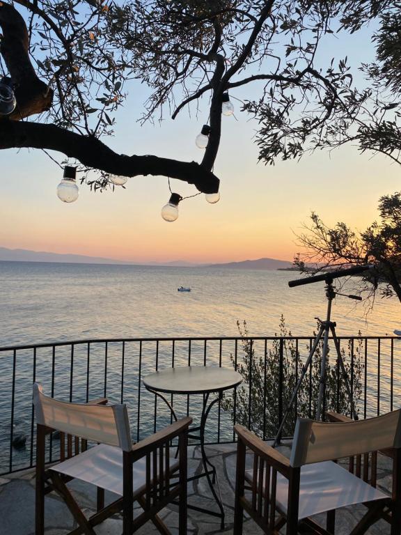 a table and chairs on a balcony overlooking the ocean at Sunset of Pelion in Kato Gatzea