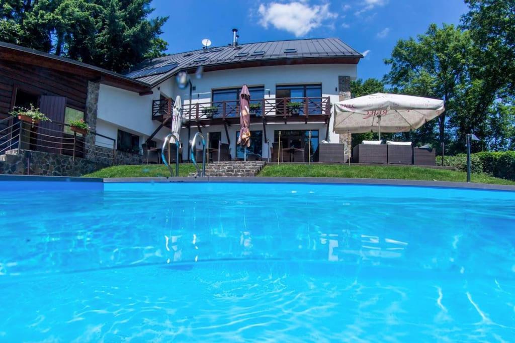a house with a swimming pool in front of a house at Vila 3 Stromy sk in Modra