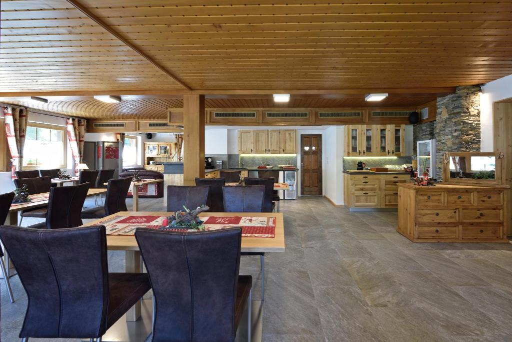 a kitchen and dining room with a table and chairs at Hotel Les Mélèzes in Haudères