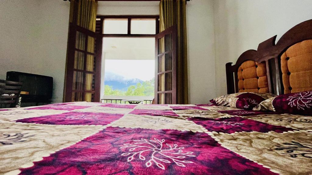 a bedroom with a large bed with a large window at White Grand Hotel in Balangoda