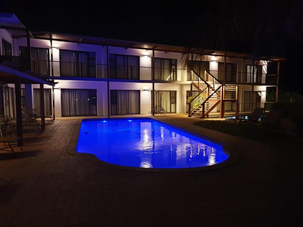 Richards Bay的住宿－The Ridge Guesthouse，一座游泳池,在晚上在建筑物前