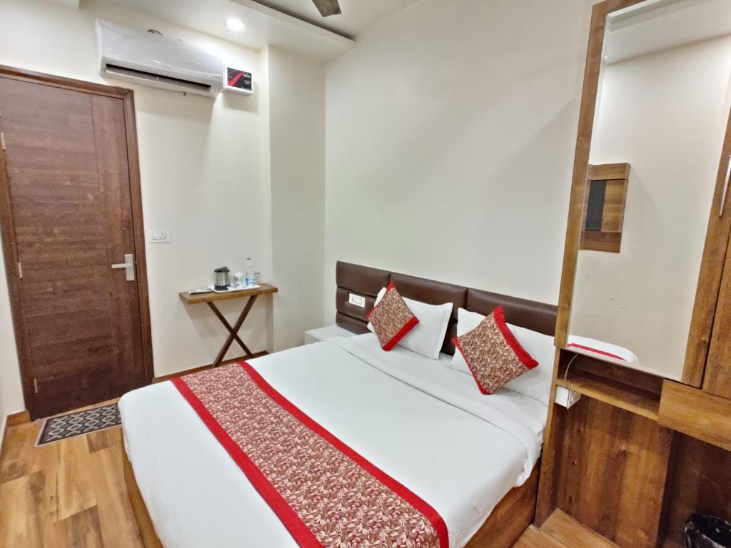 een slaapkamer met een bed en een houten deur bij Flexi Hospitality-Hotel 56 -अमृतसर का सबसे सस्ता होटल in Amritsar