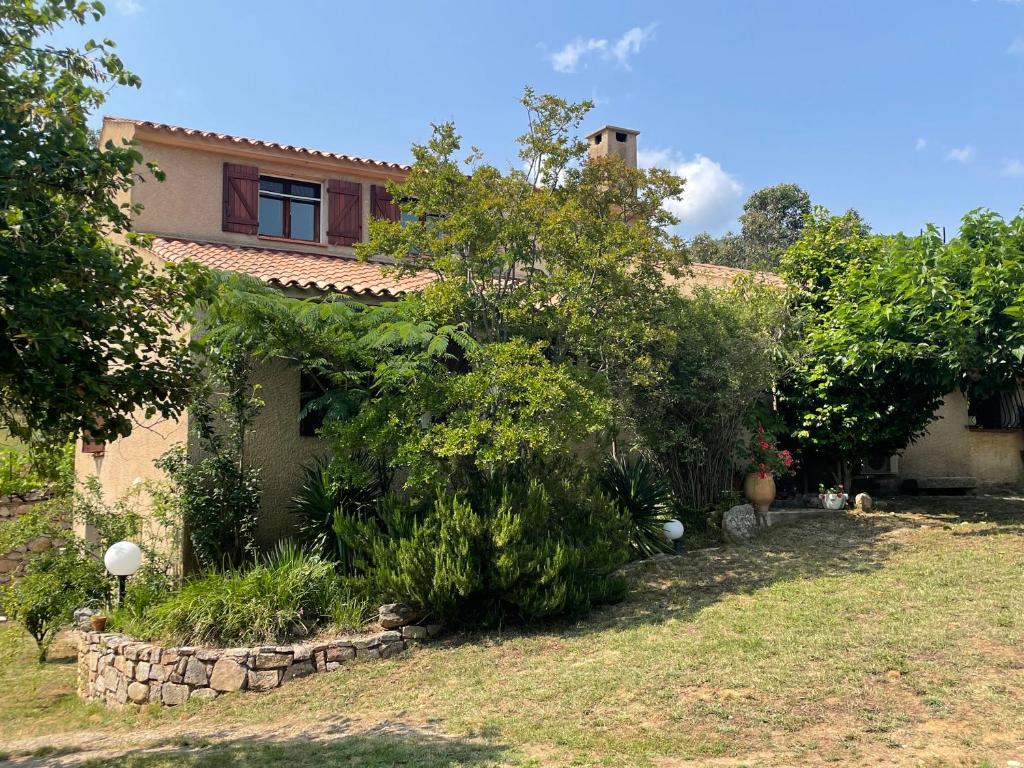 uma casa antiga com um jardim em frente em Villa de charme au coeur du maquis Corse em Tavaco