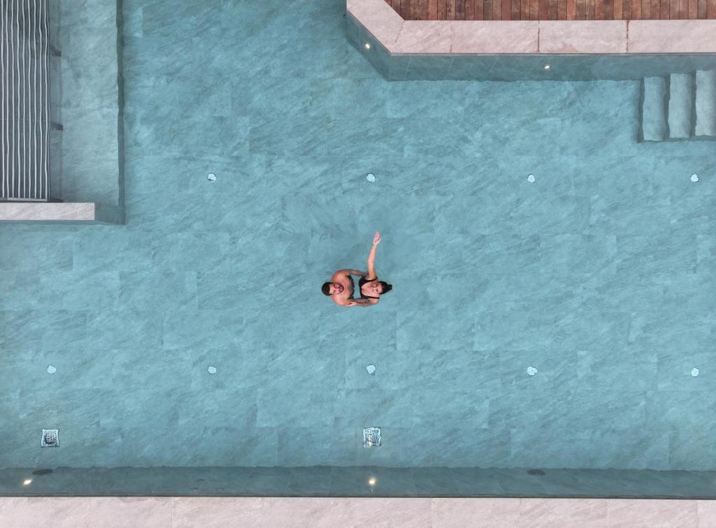 een persoon die zwemt in een zwembad bij Hotel Pozzamanigoni in Selva di Val Gardena