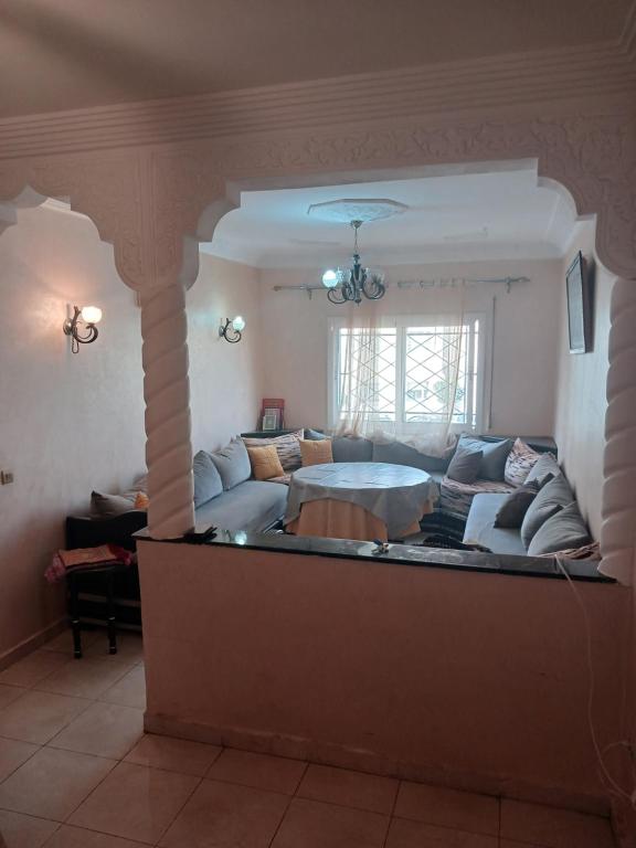 uma sala de estar com um sofá e uma mesa em Super appartement avec parking gratuit em Oujda