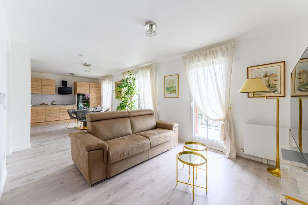 ein Wohnzimmer mit einem Sofa und einem Tisch in der Unterkunft Large bright T3 in Saint-Ouen-sur-Seine - Welkeys in Saint-Ouen