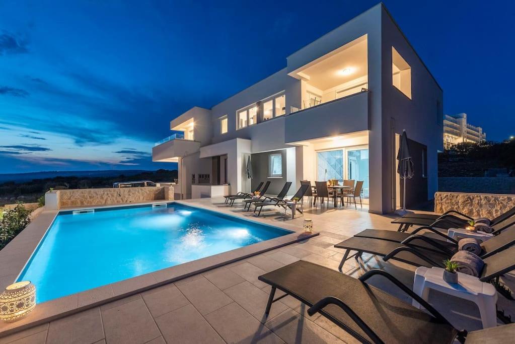 une villa avec une piscine la nuit dans l'établissement Villa Adria 1, luxury apartment with a pool, à Novalja