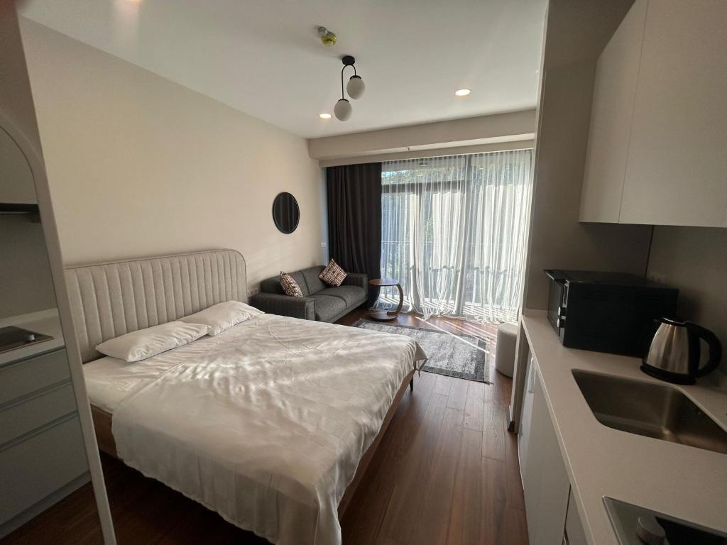 a small bedroom with a bed and a couch at BEGONYA SUİT in Yalova