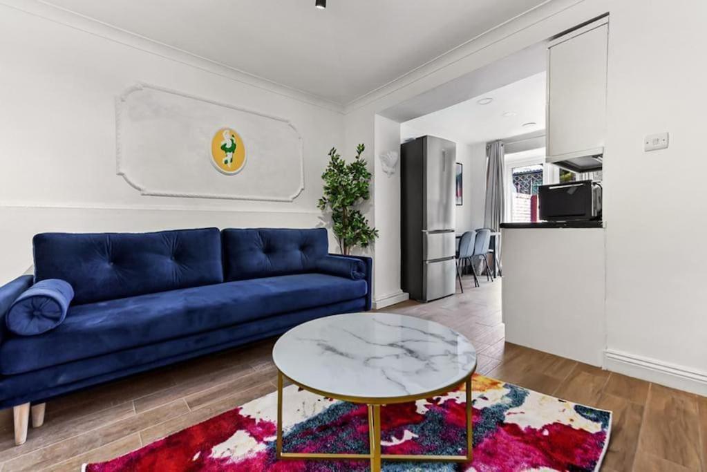 a living room with a blue couch and a table at Gorgeous Home in Islington in London