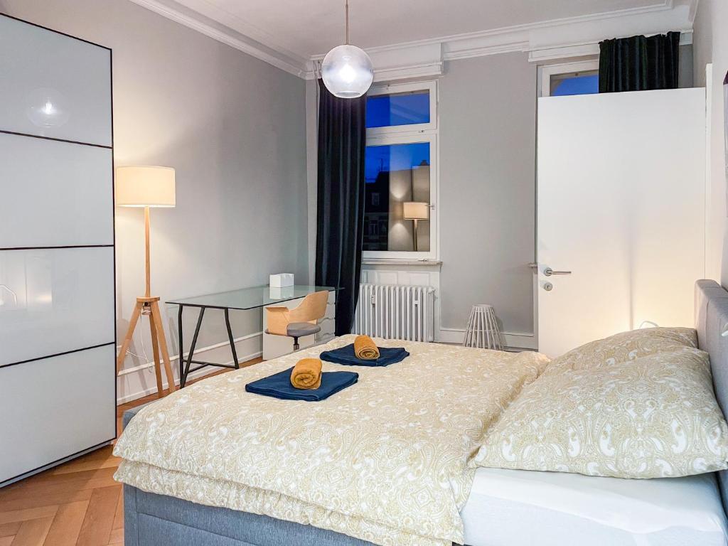 een slaapkamer met een bed met twee hoeden erop bij namastay! - Stilvoll mit Blick auf den Wasserturm in Mannheim