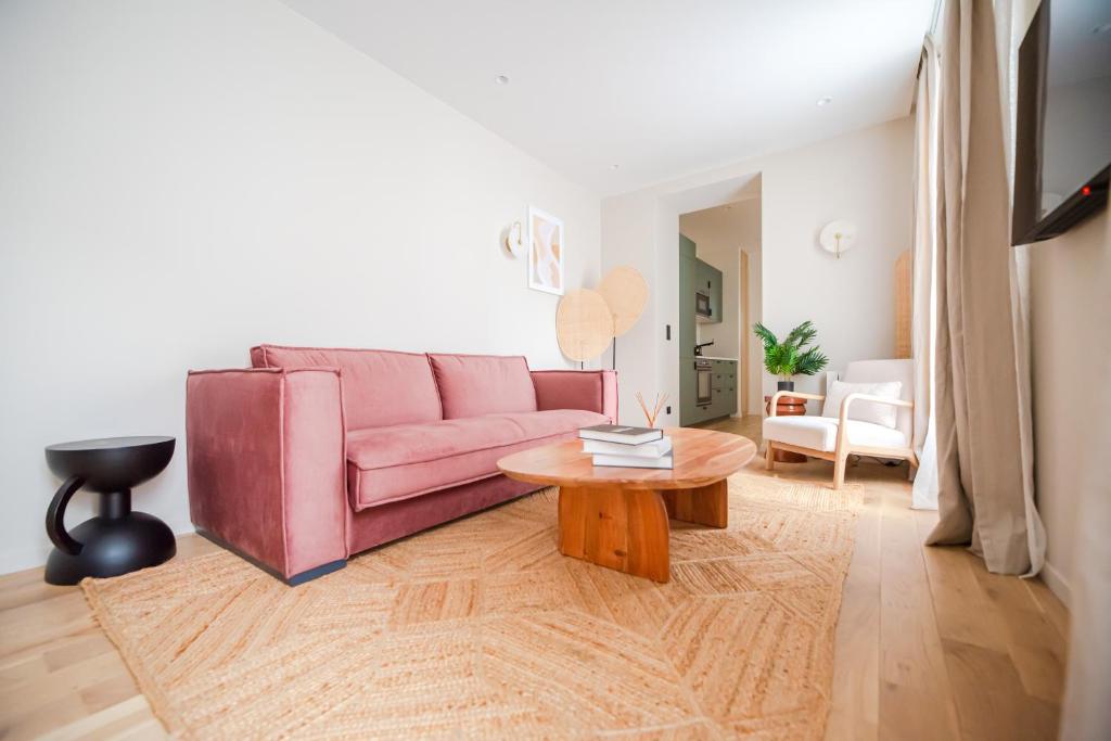 sala de estar con sofá rosa y mesa en Luxury Flat - Opera & Upper Marais en París