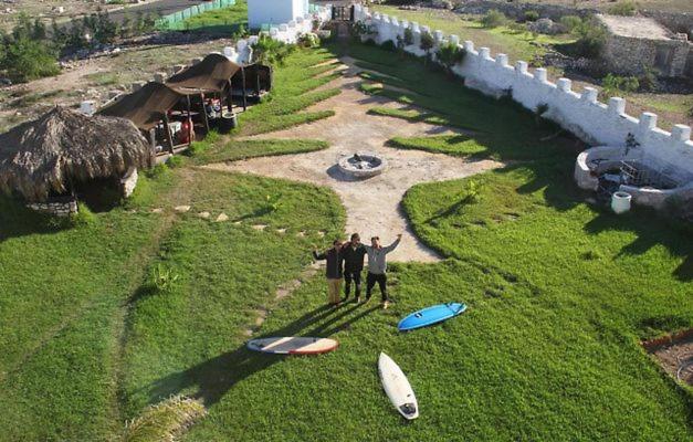 two people standing in the grass with their surfboards at sidi kaouki ayt karoum in Sidi Kaouki