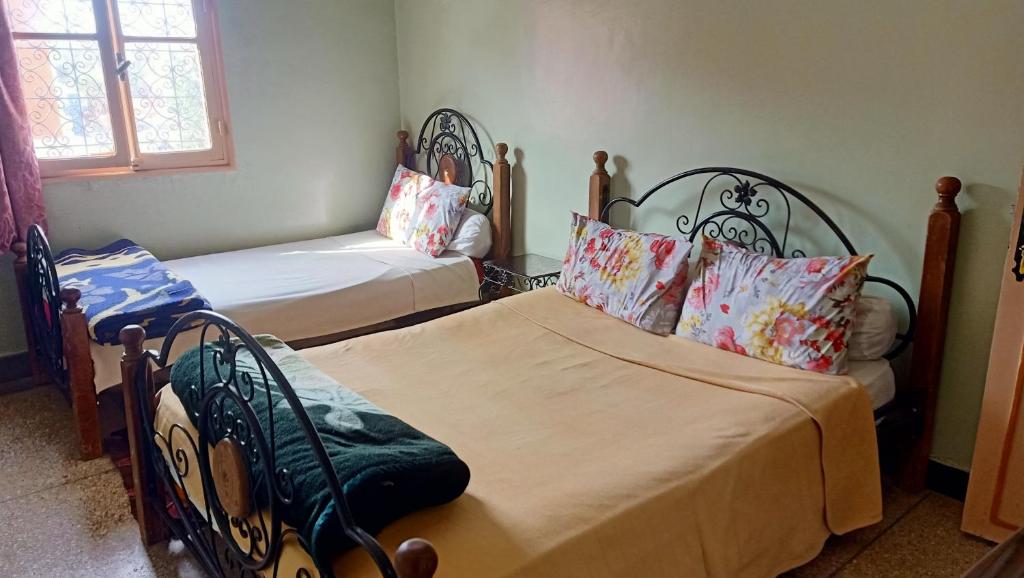 um quarto com 2 camas e uma janela em hôtel hicham em Uarzazate