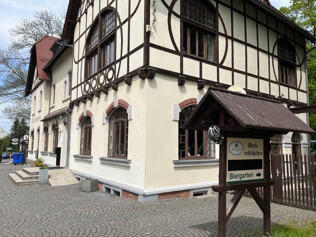 un bâtiment avec un panneau devant lui dans l'établissement Pension Parkschlösschen, à Lichtenstein