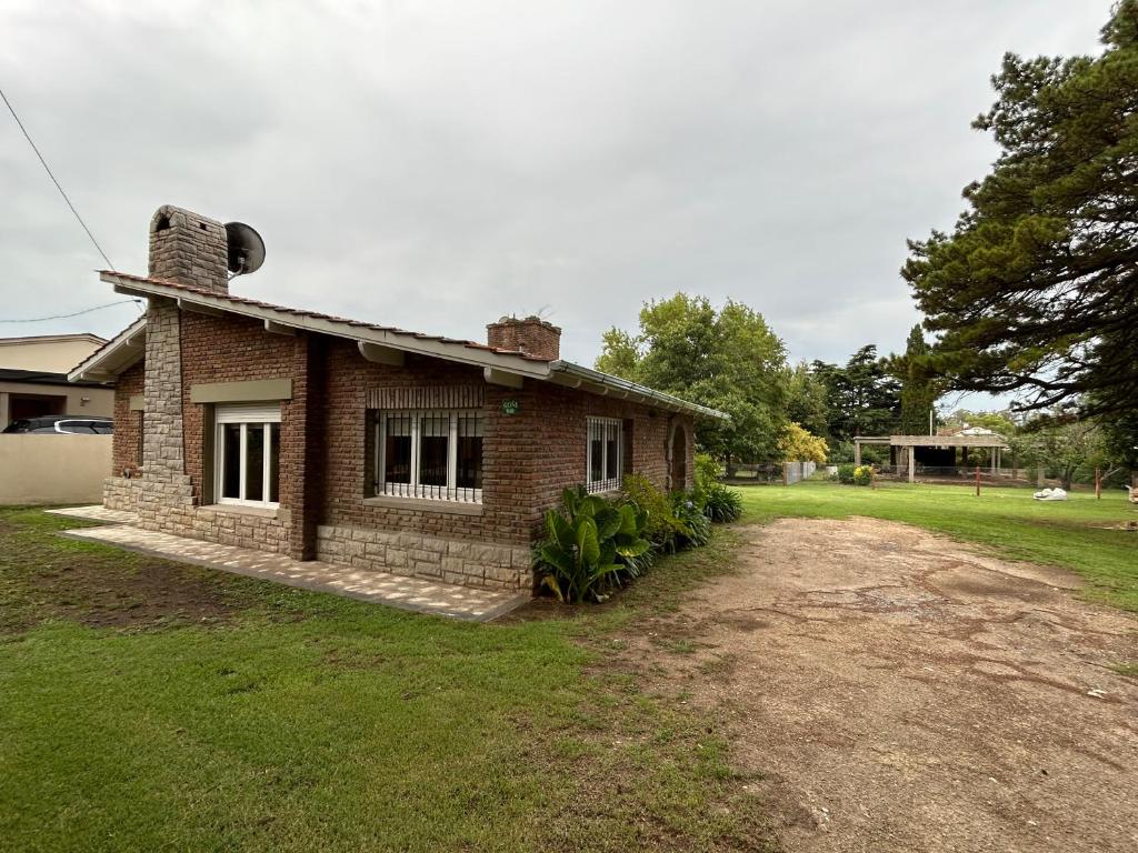 a brick house sitting on top of a yard at Lo de Nunú in Tandil