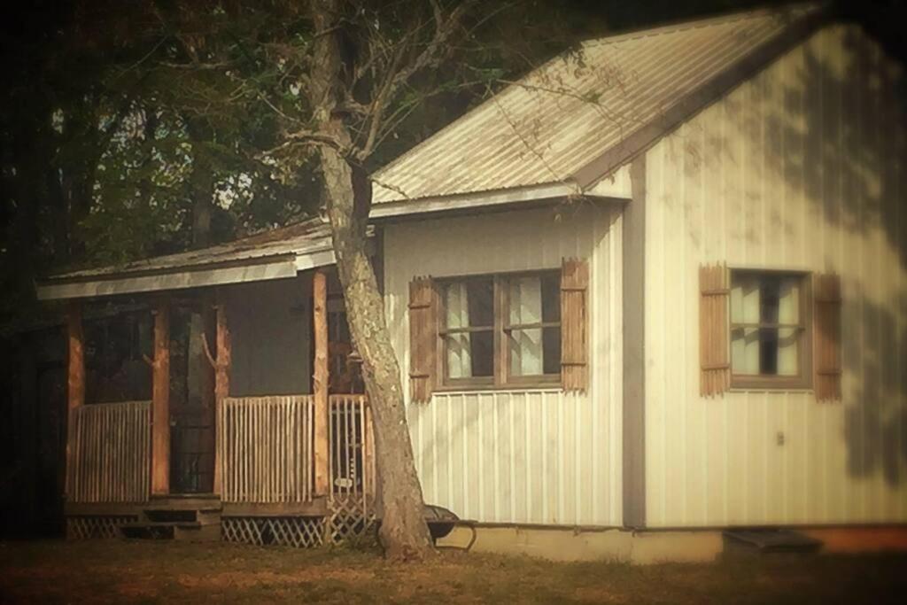 uma casa branca com uma árvore em frente em Bourbon Trail Cabin on the Farm em Lawrenceburg