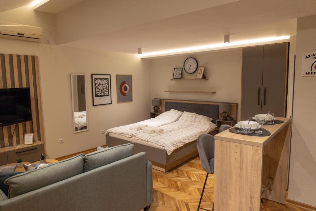 a bedroom with a bed and a living room at Apartmani Aleksandar in Vršac