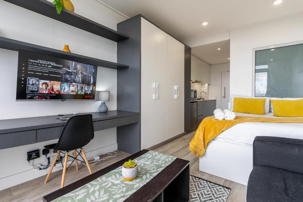 a bedroom with a bed and a tv on a wall at *One On Albert 511*Studio Apartment - Swimming Pool, WI-FI & Netflix* in Cape Town