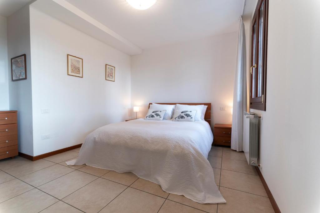 1 dormitorio blanco con 1 cama con 2 almohadas en Casa Battaglia, en Cavallino-Treporti