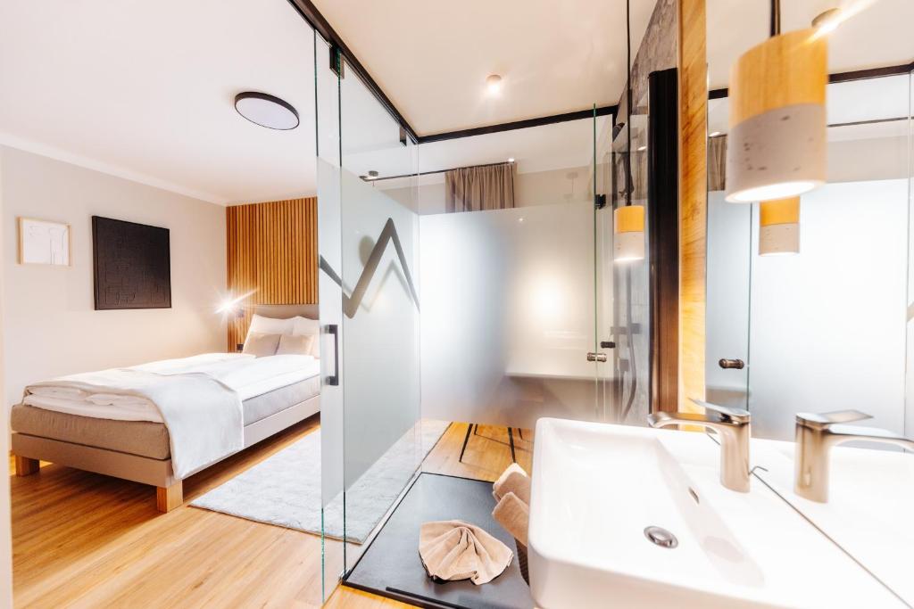 a bedroom with a bed and a sink and a mirror at Pension Linder in Seeboden