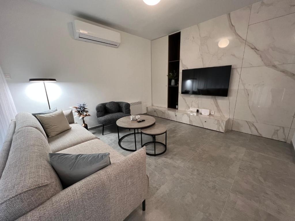 a living room with a couch and a tv and a table at Johnny's luxury getaway in Strovolos