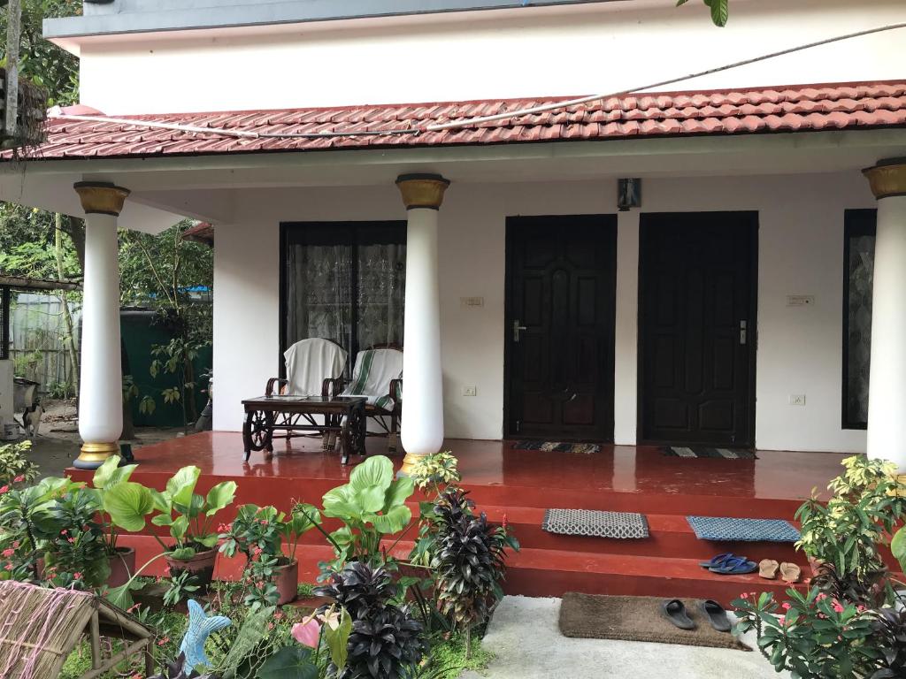 ein Haus mit einer Veranda mit zwei Türen in der Unterkunft Marari John Villa in Mararikulam