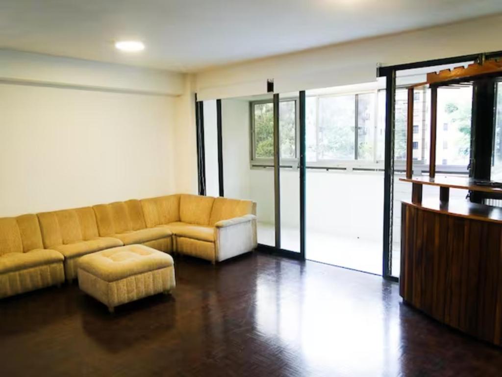 sala de estar con sofá y reposapiés en Hermoso Apartamento Familiar, en Caracas