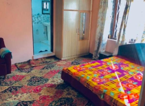 a bedroom with a colorful bed in a room at Country side cottage in Gulmarg